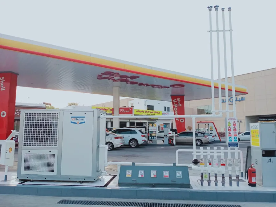 A fuel station forecourt with a vapour recovery unit beside the vent pipes.